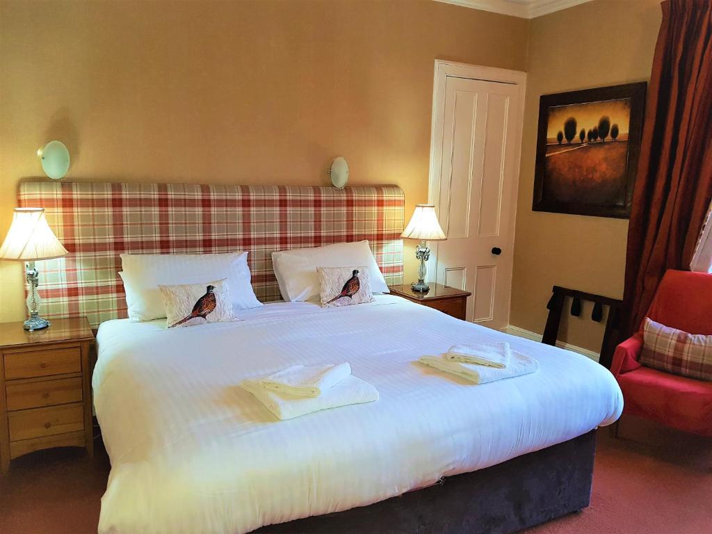 a hotel room with two beds and a lamp at Aberfeldy Lodge Guest House in Inverness