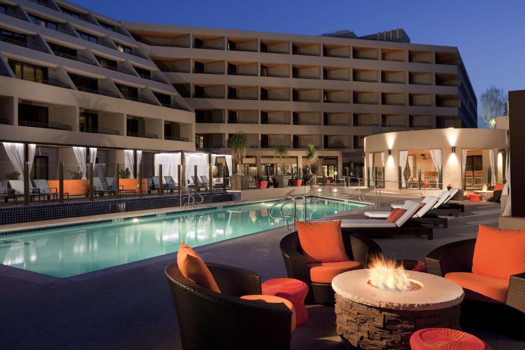 un hôtel avec une piscine, des chaises et un bâtiment dans l'établissement Hyatt Palm Springs, à Palm Springs