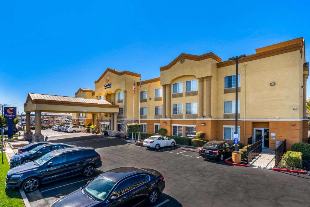 um parque de estacionamento do hotel com carros estacionados em frente em Comfort Inn & Suites Sacramento - University Area em Sacramento
