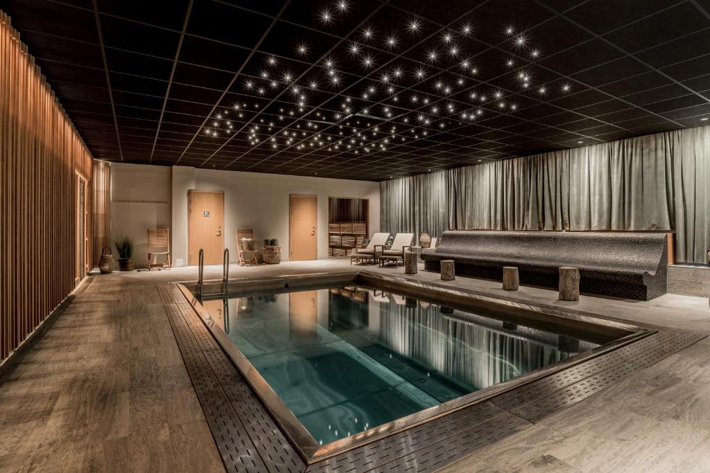 ニーショーピンにあるBlommenhof Hotelのソファ付きの客室の中央にプールがあります。