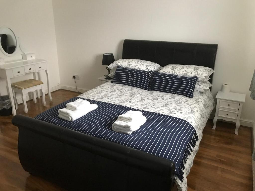 um quarto com uma cama grande e toalhas em Charimore Relaxation House em Abbey Wood
