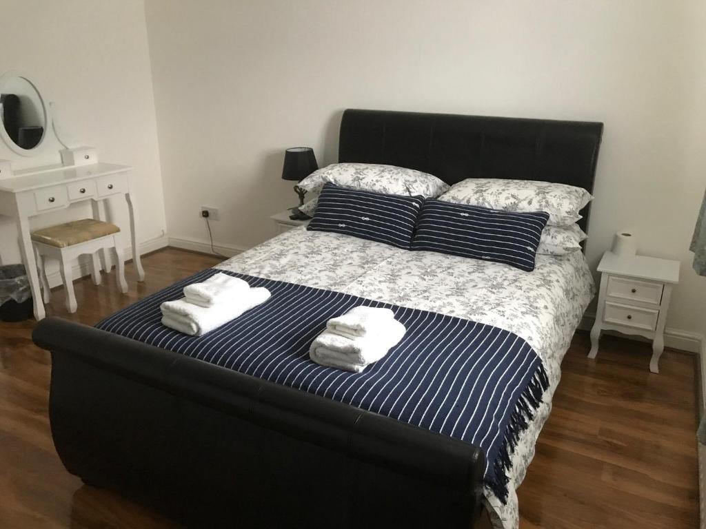 a bedroom with a large bed with towels on it at Charimore Relaxation House in Abbey Wood