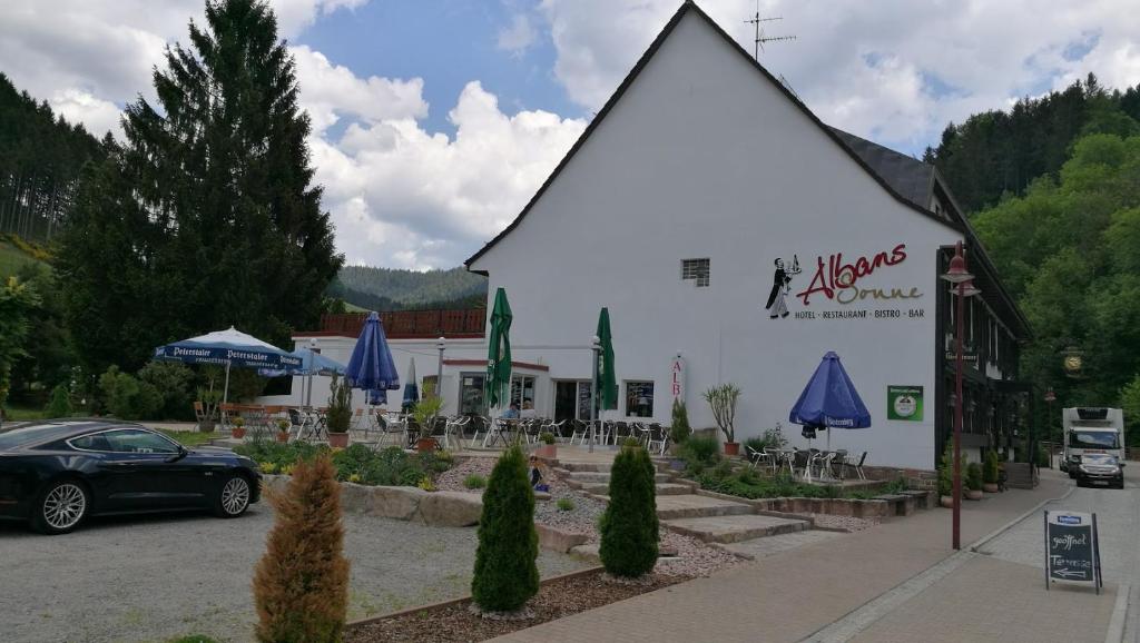 un bâtiment avec une voiture garée devant lui dans l'établissement Hotel Restaurant Albans Sonne, à Bad Rippoldsau-Schapbach