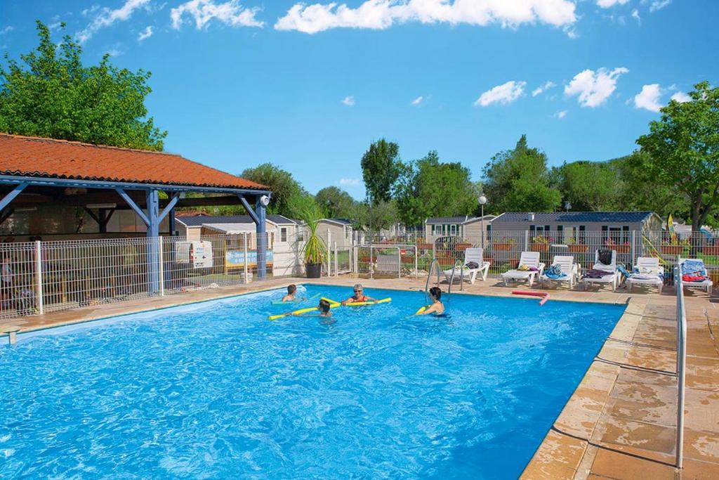 a group of children playing in a swimming pool at Mobil Home 3 ch in Saint-Georges-de-Didonne