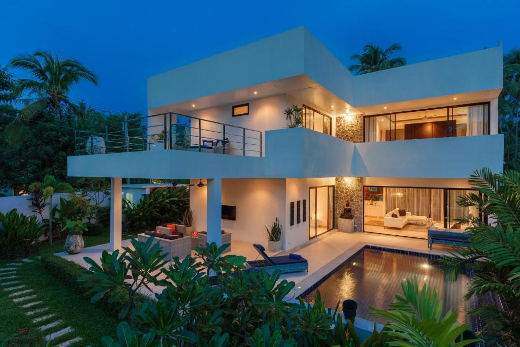 a villa with a swimming pool at night at Baan Siri Varee - Private Village Luxury in Ban Tai, Koh Samui in Mae Nam