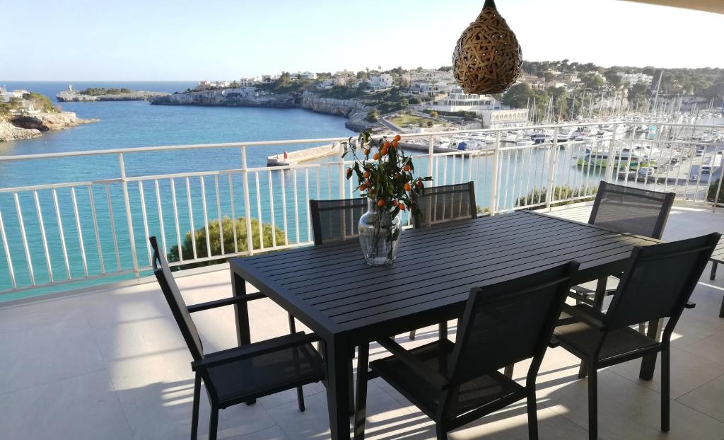een zwarte tafel met stoelen en een vaas met bloemen op een balkon bij Àtic bordils in Porto Cristo