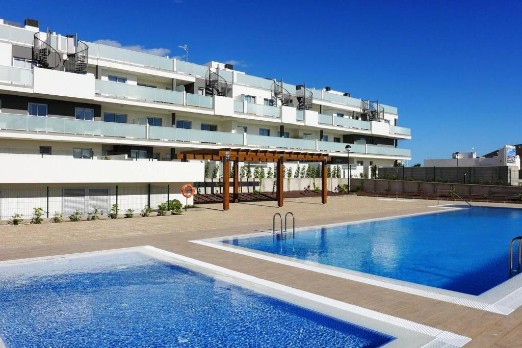 una piscina frente a un gran edificio en Cosy apartment - 4 min walk from the beach - La Tejita El Medano, en La Tejita