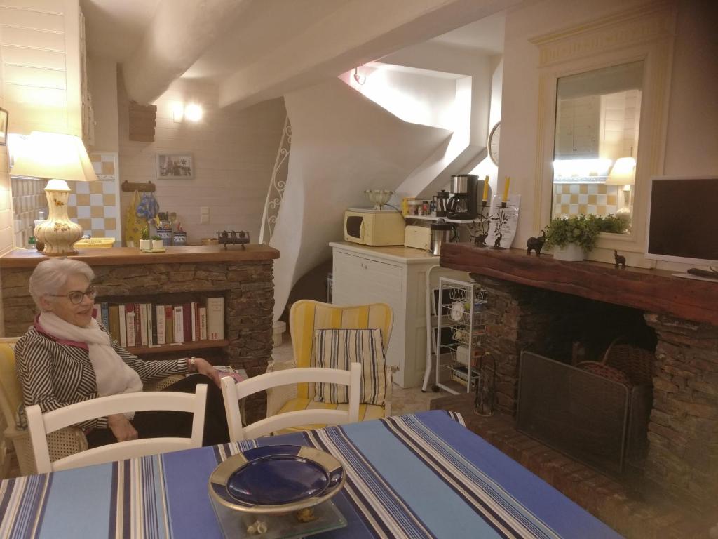 een vrouw aan een tafel in een keuken bij 3 Rue Marceau in Collioure