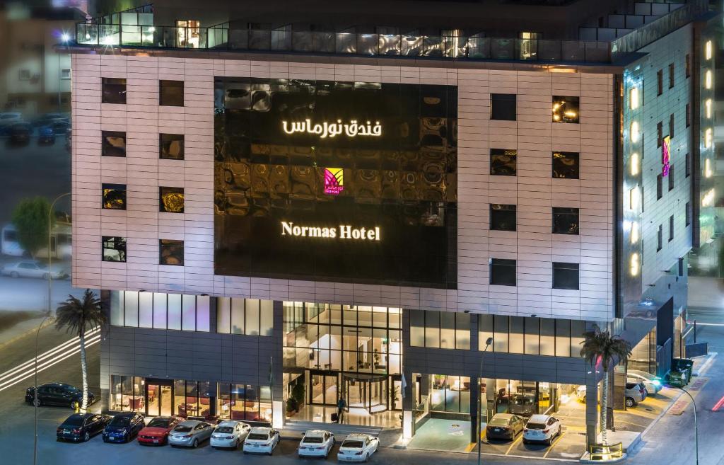 un gran edificio con coches estacionados frente a él en Normas Hotel en Al Khobar