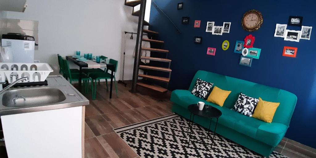 Il comprend un salon avec un canapé vert et une cuisine. dans l'établissement Home away from home, à Novi Sad