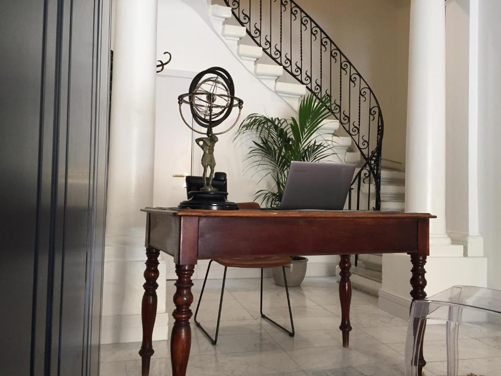 a desk with a laptop on it next to a staircase at The Barrister Hotel in Valletta