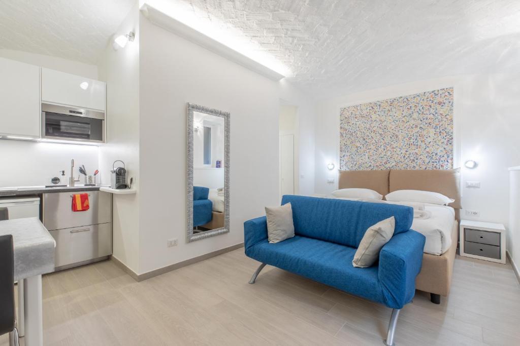 ein Wohnzimmer mit einem blauen Sofa und einem Bett in der Unterkunft Dolce Vita New Studio in Rom