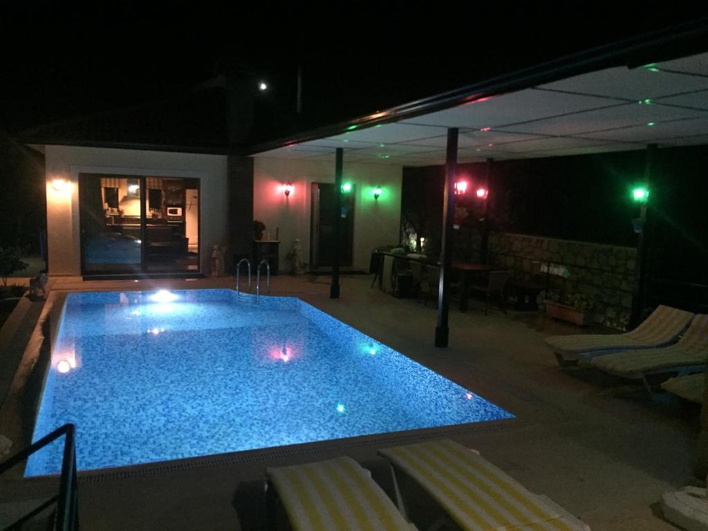 a swimming pool at night with chairs around it at Villa Antalya Esiyok in Antalya