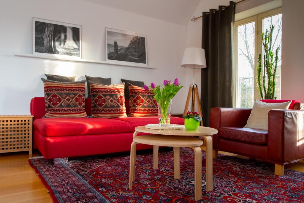 ein Wohnzimmer mit einem roten Sofa und einem Tisch in der Unterkunft Apartment Haak in Halle Westfalen