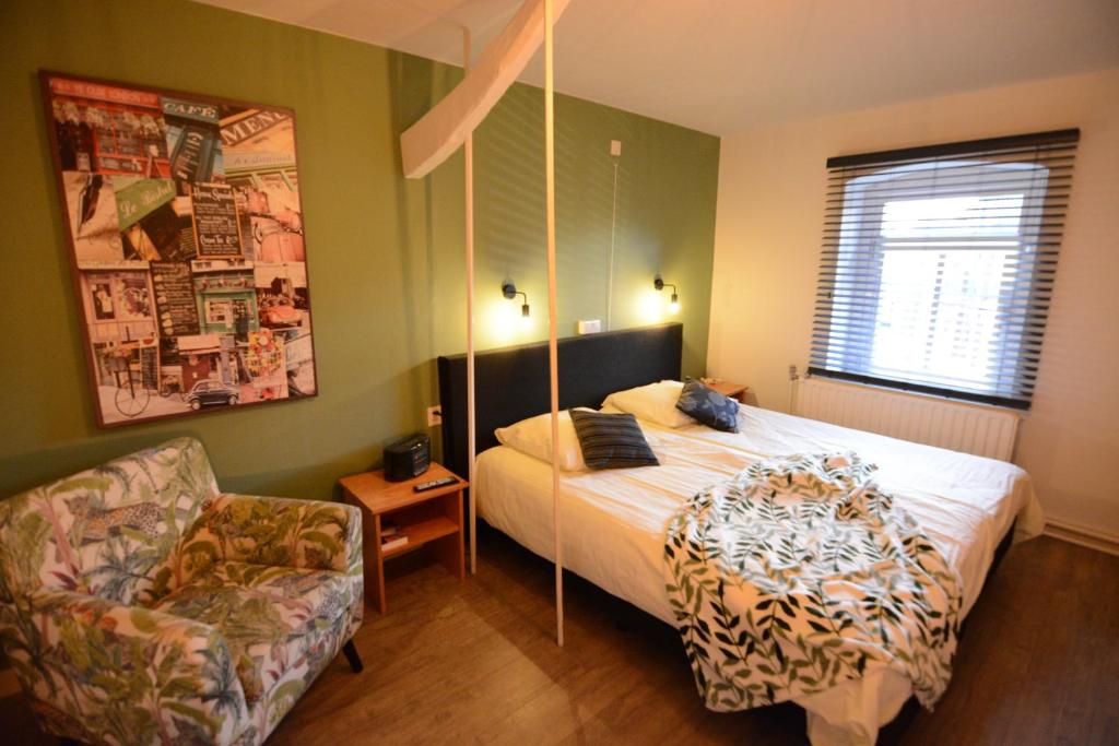 ein Schlafzimmer mit einem Bett und einem Stuhl in der Unterkunft Hotel De Beukelaer in Roggel