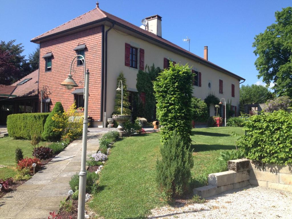 a house with a green yard in front of it at L'Ancienne Cure in Besain