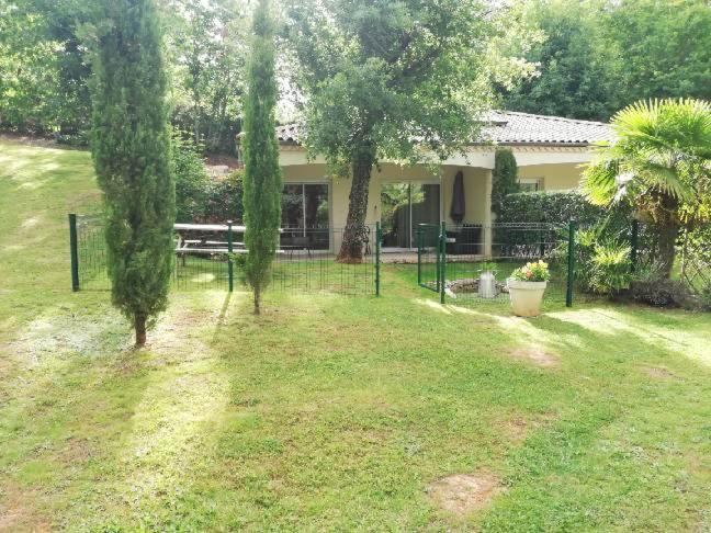 a yard with a bench and trees in front of a house at Le Mas des Geais in Atur