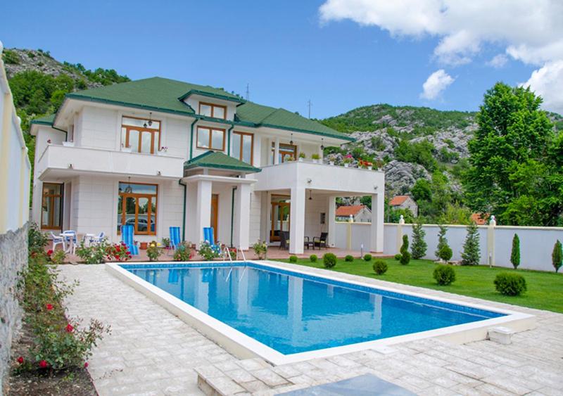 uma casa grande com uma piscina em frente em Villa Ramonte em Cetinje