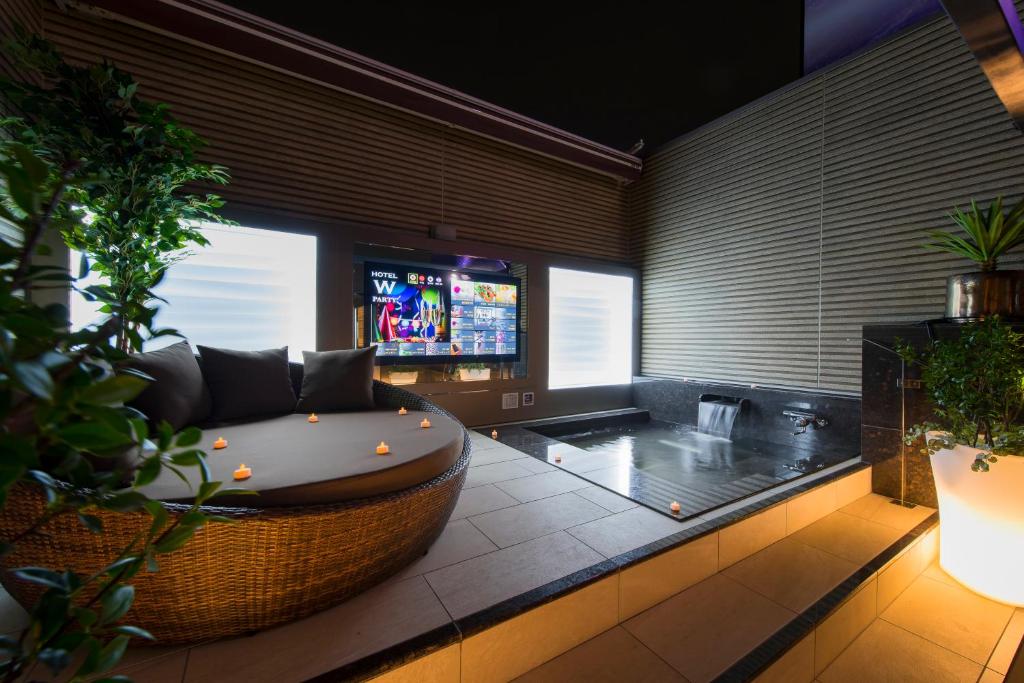 a living room with a couch and a tv at HOTEL W-PARTY-W GROUP HOTELS and RESORTS- in Kawaguchi