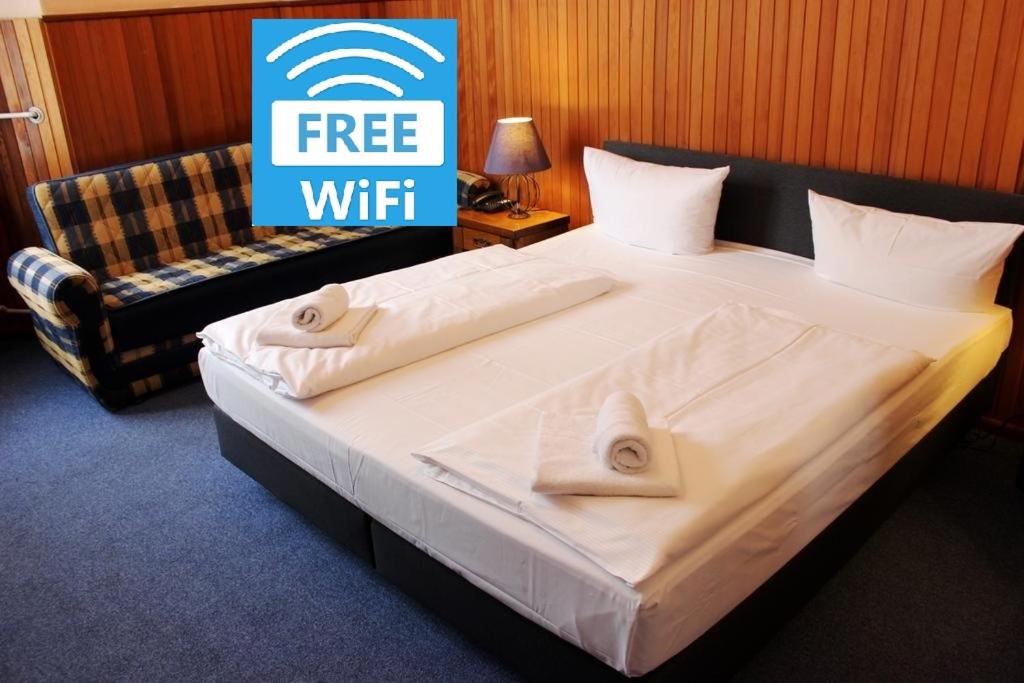 un grande letto in una stanza con un cartello che dice wifi gratuito di Hotel-Pension Rheingold am Kurfürstendamm a Berlino