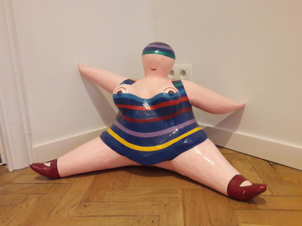 a plastic doll in a swimsuit sitting on the floor at Un grand jardin en ville. Chez Guy in Brussels