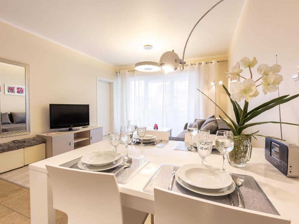 jadalnia z białym stołem i krzesłami w obiekcie VacationClub – Stella Baltic Apartament 37 w Świnoujściu