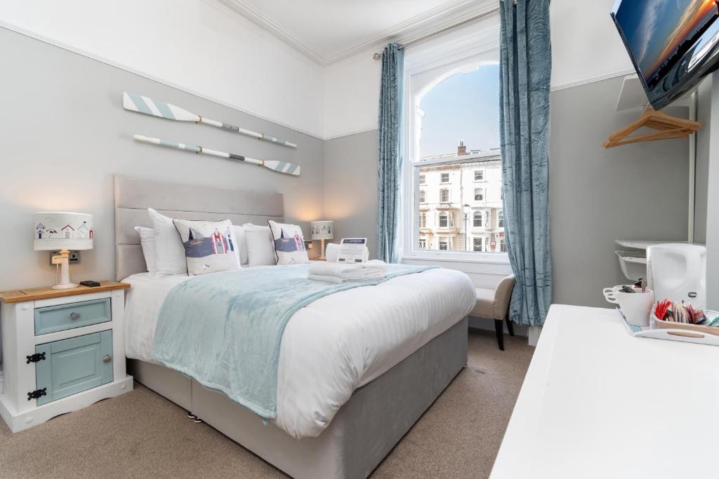 a bedroom with a large bed and a window at Beachside Guest House in Llandudno