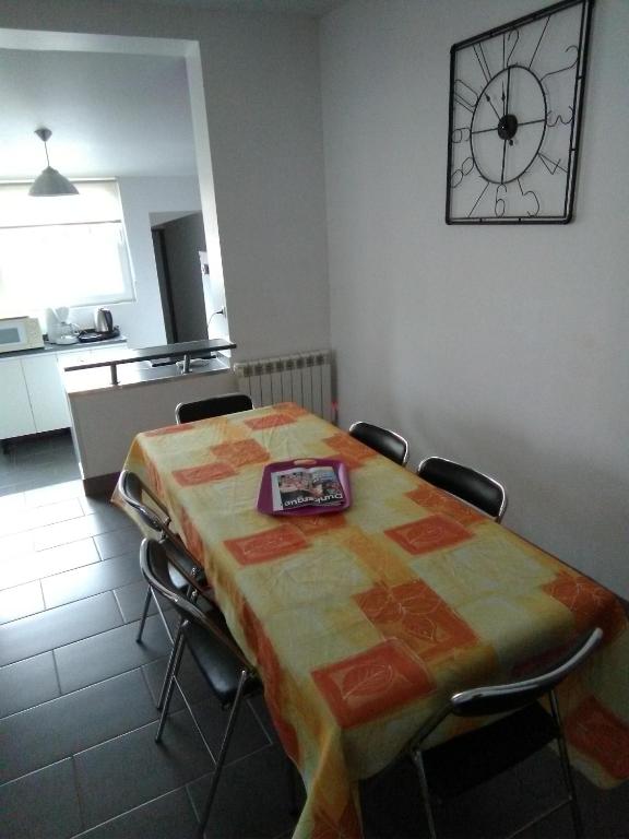 Cette chambre comprend une table avec des chaises et une horloge murale. dans l'établissement Gîte sur St Pol sur mer de 2 à 8 couchages, à Saint-Pol-sur-Mer