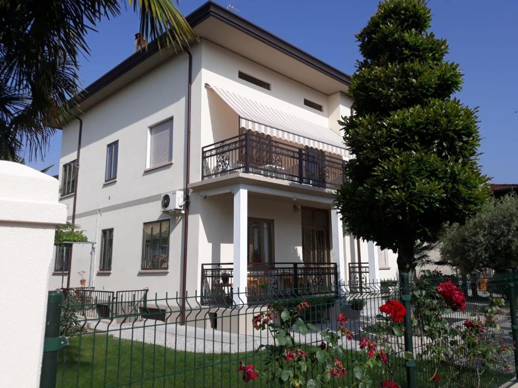 a white house with a balcony and a tree at CASA ROMAN ITALIA, Center Sacile in Sacile