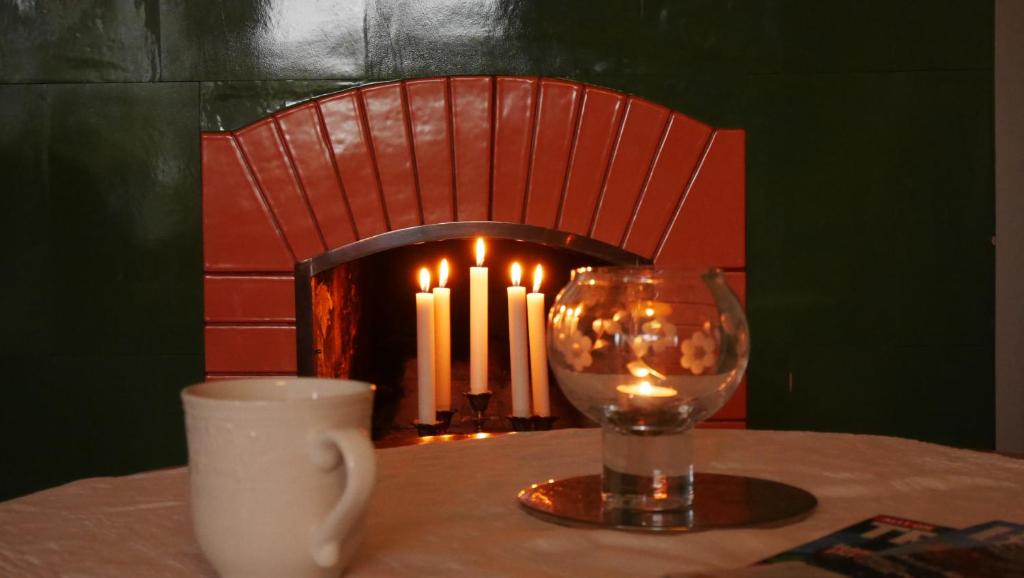 Pensionat Solhöjden في ماريانلود: طاولة فيها شمعة وكوب وكوب