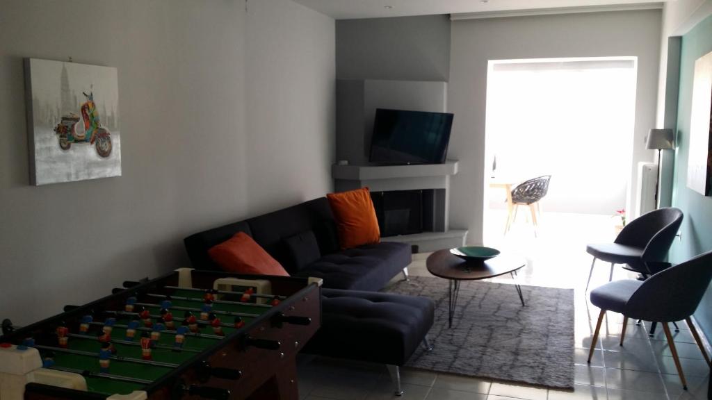 a living room with a couch and a foosball table at Athenian Luxury apartment, near metro station Chalandri, Nu 2 in Athens
