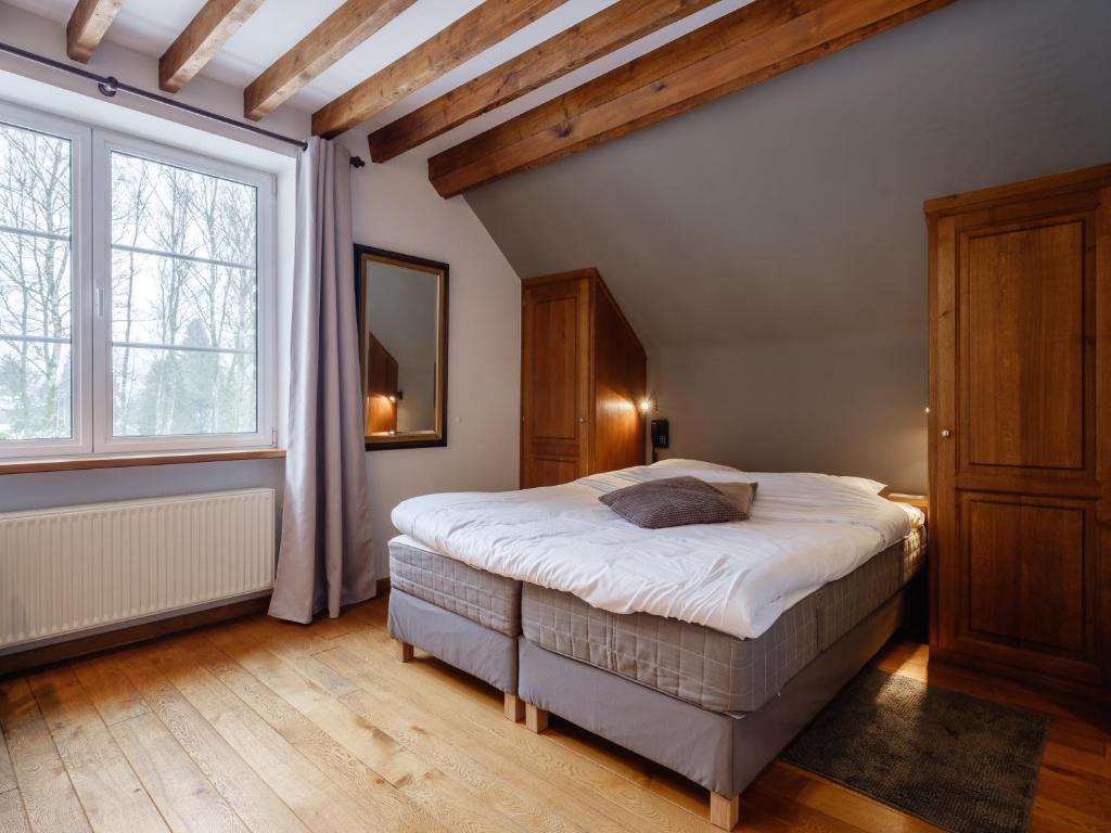 a bedroom with a bed and a large window at Hotel Auberge D'Alle in Alle