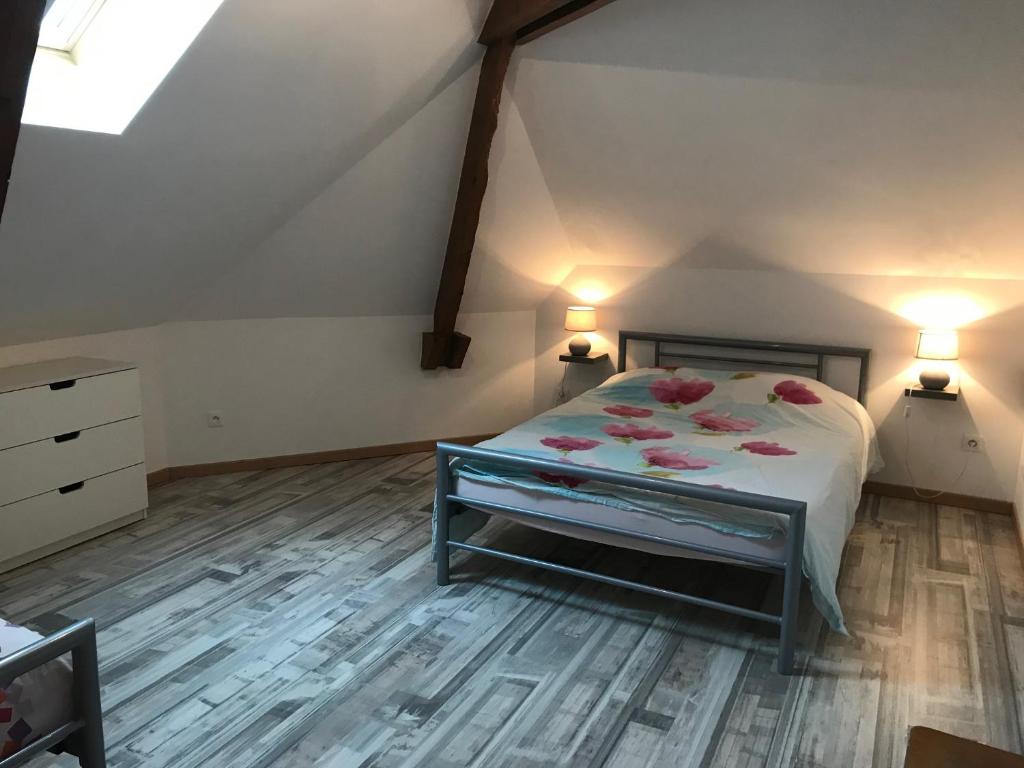 una camera da letto con un letto con fiori rosa di Le gîte du Canal des Ardennes a Le Chesne
