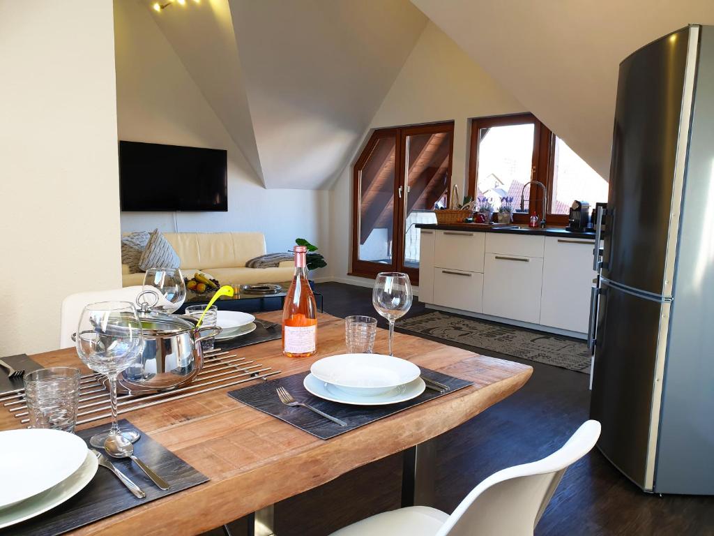 a kitchen with a wooden table with plates and wine glasses at Seeperle 4 in Meersburg