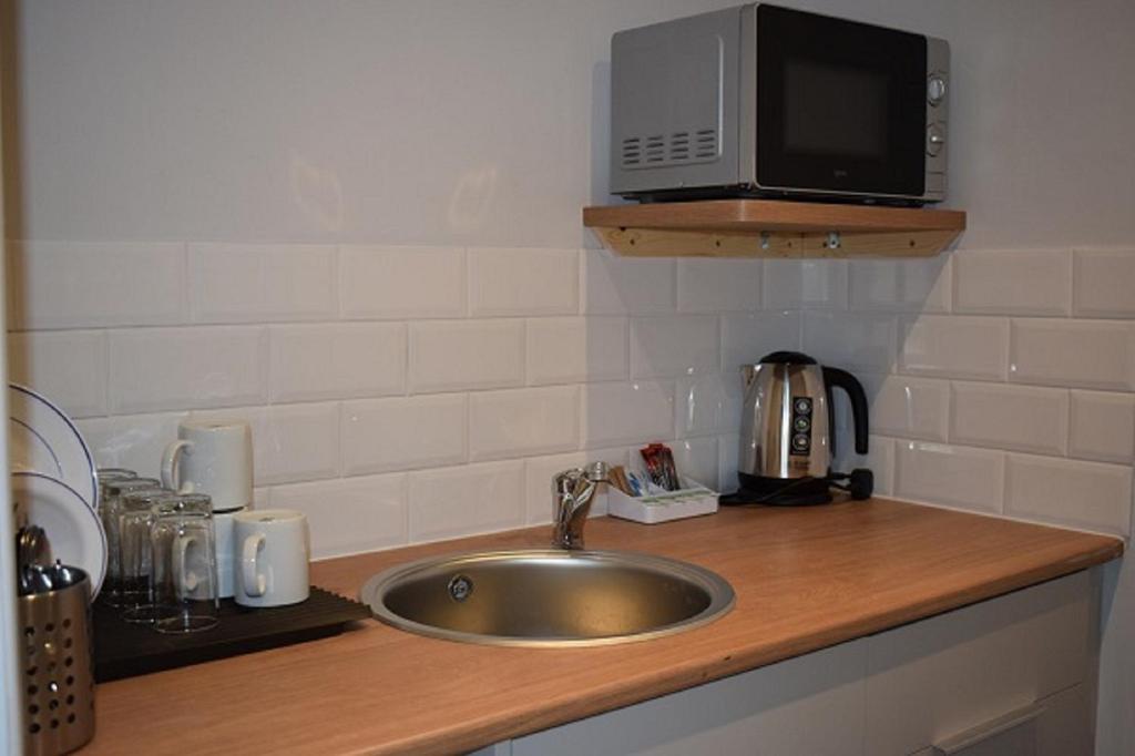 a kitchen counter with a sink and a microwave at Newlands Holidays in Bridport