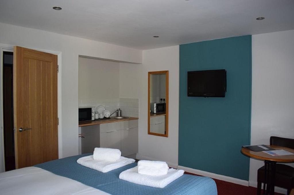 a hotel room with a bed with two towels at Newlands Holidays in Bridport