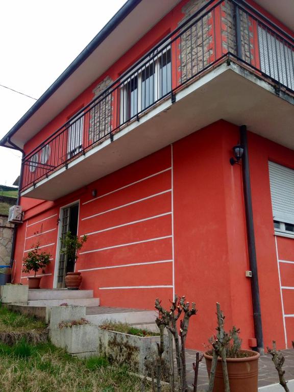 a red house with a balcony at Appartamento Antonio in Malo