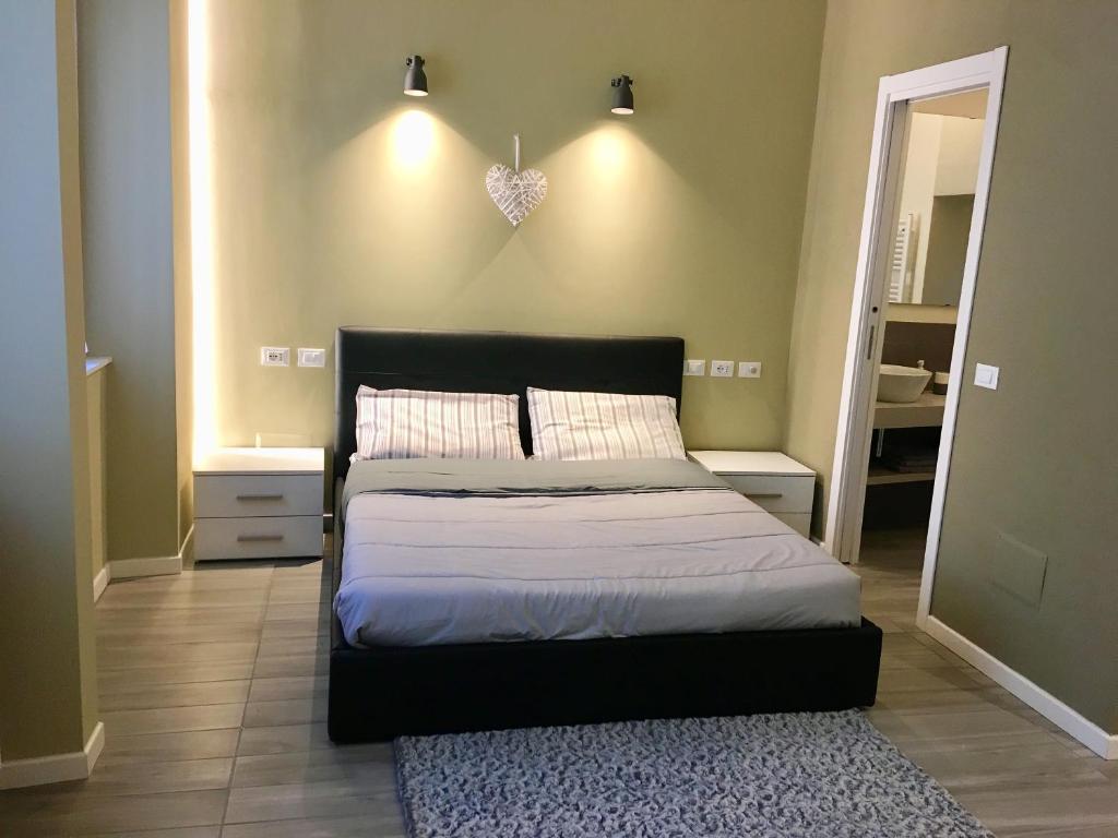 ein Schlafzimmer mit einem großen Bett und einem Spiegel in der Unterkunft MONOLOCALE VICINO MILANO1 in Lodi