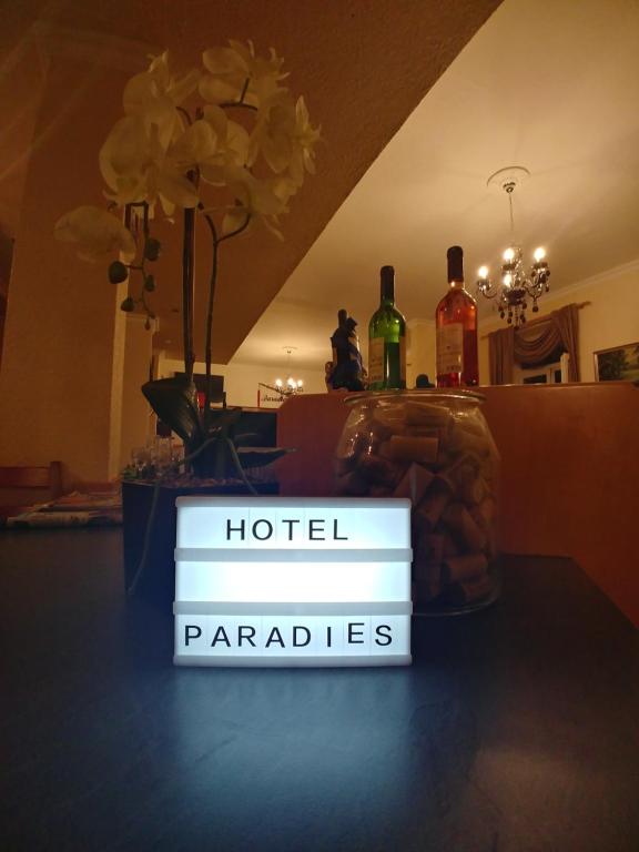 HatzenportにあるHatzenporter Paradiesのホテルの並木をテーブルに座って読む看板