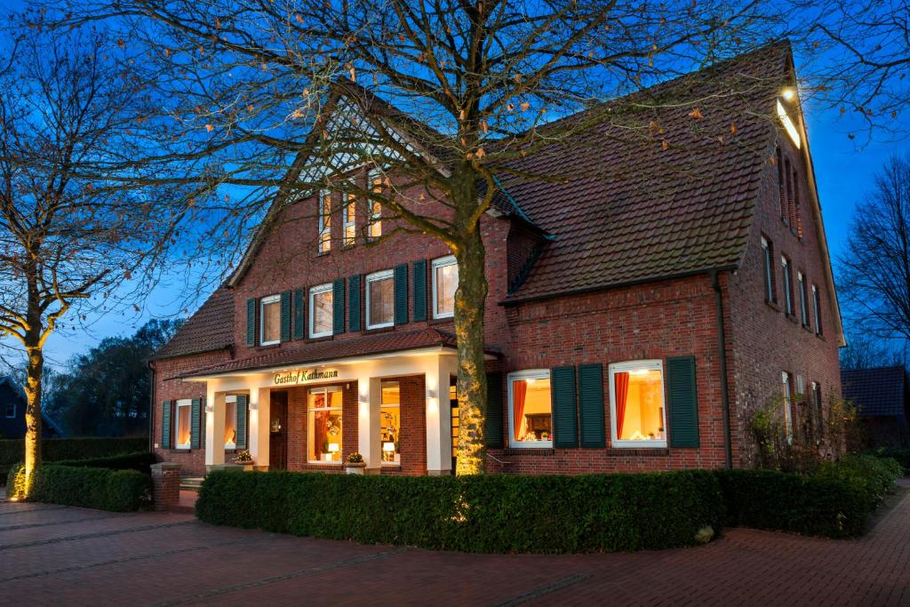 a large brick house with lights in the windows at Landgasthaus Kathmann- bed and breakfast in Dinklage
