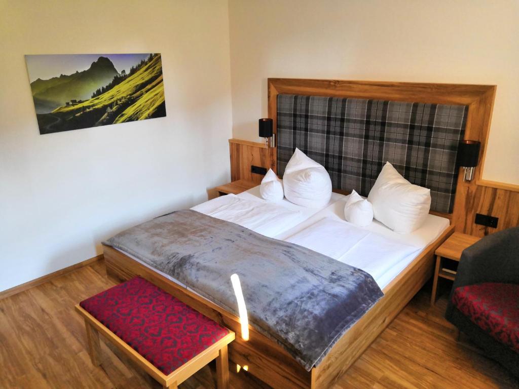 - une chambre avec un grand lit et un tabouret rouge dans l'établissement Gasthof Schwarz, à Mehring