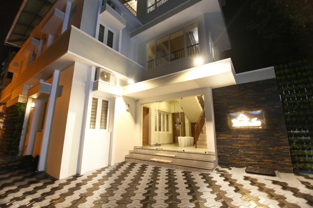 a white house with a staircase and a balcony at Castilo Inn Hotel Apartments in Cochin