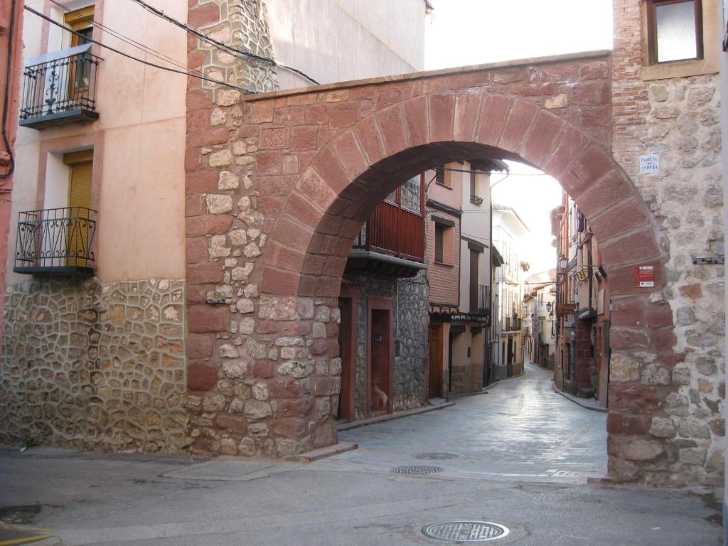 un callejón con un arco en un edificio de ladrillo en Casa Artigot en Gea de Albarracín