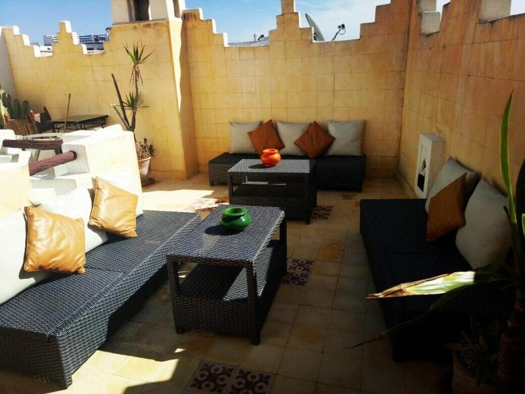 een patio met banken en een tafel bij LES EMBRUNS D'ESSAOUIRA in Essaouira
