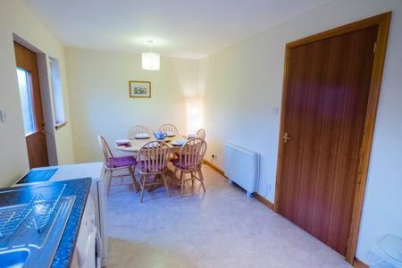 eine Küche und ein Esszimmer mit einem Tisch und Stühlen in der Unterkunft Sunbury Aviemore in Aviemore