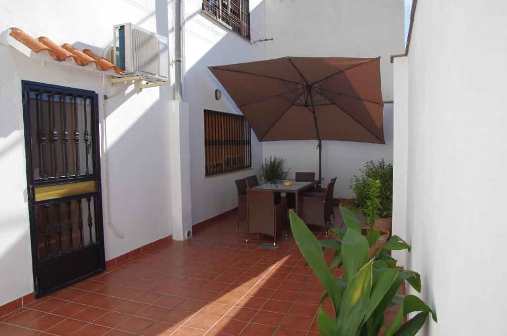 a patio with a table and an umbrella at Apartamento Turístico San Jorge Parking Privado Gratis in Cáceres