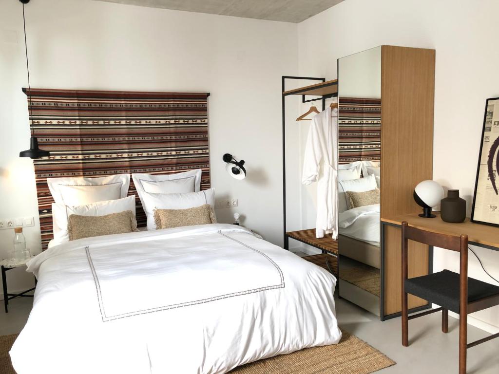 Un dormitorio con una gran cama blanca y un escritorio. en Casa Figa 39, en Zagreb