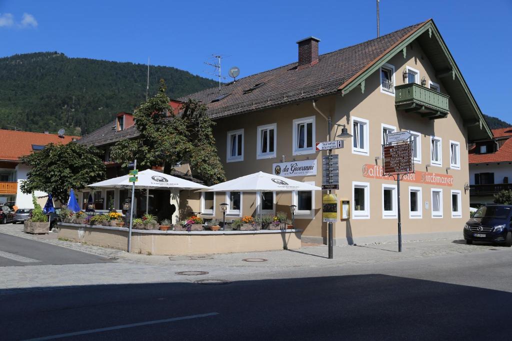 a building with white umbrellas in front of it at Landgasthof Kirchmayer in Farchant