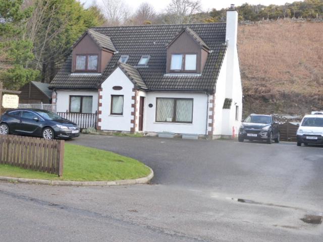 a house with two cars parked in a driveway at Dacama House in Ullapool