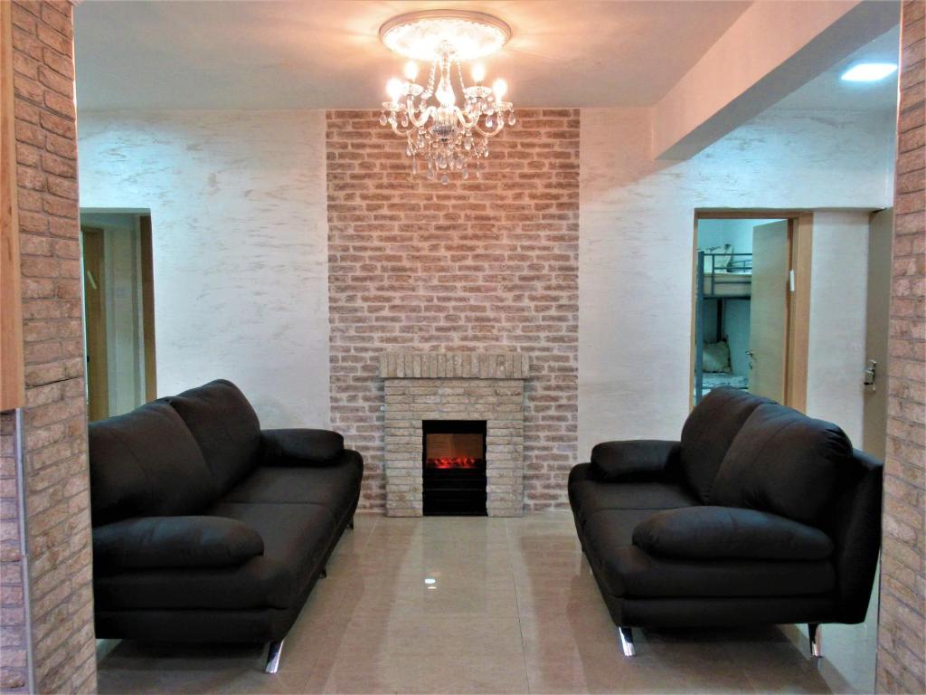 a living room with two leather couches and a fireplace at Moab Palaces in Arad
